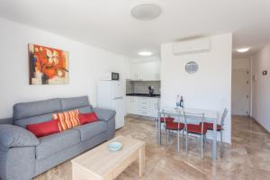 a living room with a couch and a table and a kitchen at Lightbooking Teror Playa del Ingles in San Bartolomé