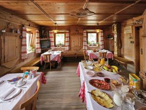a dining room with two tables with food on them at Pension Aichner in Terento