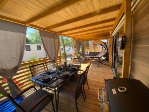 a wooden deck with a table and chairs on it at Mobile Home Saky, Camp Soline in Biograd na Moru