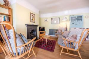 a living room with a couch and chairs and a fireplace at 8 The Craighurst in Southwold