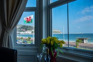 a room with a window with a view of the ocean at Promenâd Bed & Breakfast in Llandudno