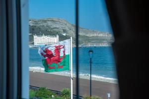 una ventana con bandera y vistas a la playa en Promenâd Bed & Breakfast, en Llandudno