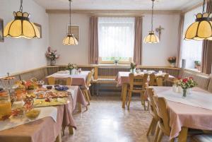 a dining room with tables and chairs and lights at Pension Schwaiger in Bad Gögging