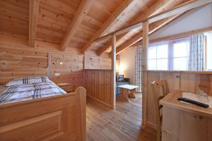 Dormitorio en cabaña de madera con cama y escritorio en Agriturismo Soleseid, en San Vigilio Di Marebbe
