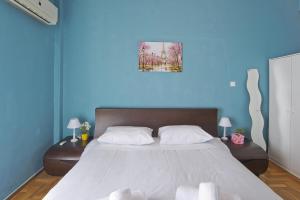 - une chambre avec un grand lit et un mur bleu dans l'établissement Andromaxi near SNFCC, à Athènes