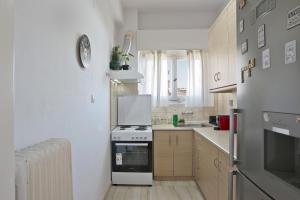 - une cuisine blanche avec cuisinière et évier dans l'établissement Andromaxi near SNFCC, à Athènes