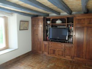 a living room with a tv and a book shelf at Etxetxobarri, caserío independiente con vistas a la crestería de Anboto 