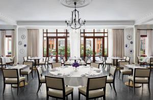 a dining room with tables and chairs and a chandelier at Hotel Bristol, A Luxury Collection Hotel, Warsaw in Warsaw