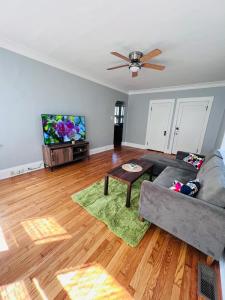 uma sala de estar com um sofá e uma televisão de ecrã plano em Dale first floor em Richmond Heights