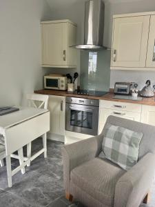 a kitchen with a couch and a table and a microwave at Fern Cottage in Lynton