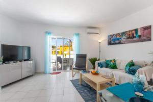 - un salon avec un canapé et une télévision dans l'établissement Apartment Feliz, à Carvoeiro