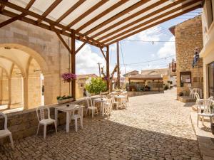 un patio avec des tables et des chaises dans un bâtiment dans l'établissement Sanders Village, à Vasa Kilaniou