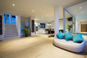 Una sala de estar con un sofá blanco con almohadas azules. en Villa Monsoon, en Nathon Bay