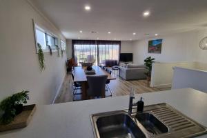 a kitchen with a sink and a living room at The Bunker Normanville in Normanville