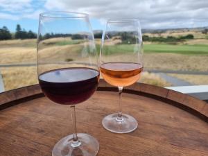 two glasses of wine sitting on a wooden table at The Bunker Normanville in Normanville