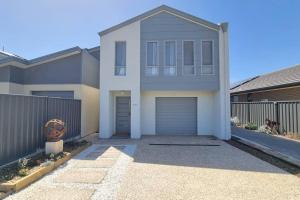 a house with a garage in front of a fence at The Bunker Normanville in Normanville