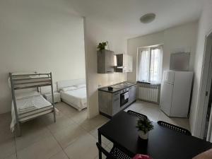 een keuken met een koelkast en een tafel en een bed bij Le dimore di San Gervasio in Capriate San Gervasio
