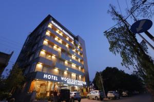 a hotel with a sign on the front of it at Hotel Woodside Prestige in Tirupati