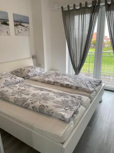 a bedroom with two beds and a window at Strandläufer in Butjadingen OT Tossens