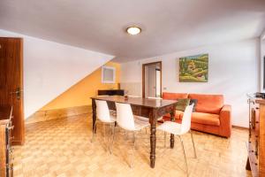 - une salle à manger avec une table, des chaises et un canapé dans l'établissement Incanto Walser Apartments Piazza, à Macugnaga