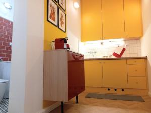 uma cozinha com armários amarelos e um lavatório em Art & Design Studios em Budapeste