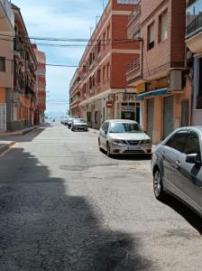 una calle de la ciudad con coches aparcados en la carretera en Mar Menor, en San Pedro del Pinatar