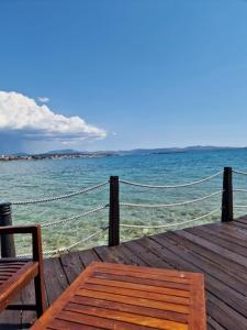 a wooden dock with a bench and the ocean at Dream in Sibenik in Šibenik