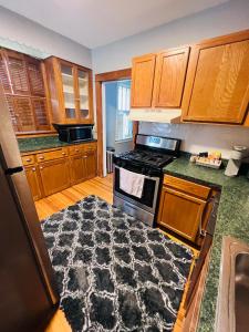 uma cozinha com armários de madeira e um tapete preto em Dale first floor em Richmond Heights