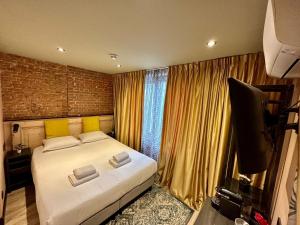 a bedroom with a large bed and a television at BEAUTiQUE HOTEL CITY CENTRE in Amsterdam