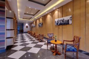 a waiting room with chairs and a checkerboard floor at Amarpreet, Chhatrapati Sambhajinagar - AM Hotel Kollection in Aurangabad