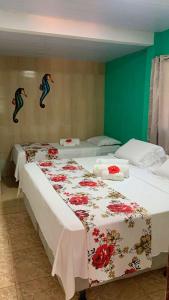 two beds in a room with mermaids on the wall at Flat Visual do Porto in Fernando de Noronha