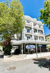 a white building with a sign in front of it at Residence Mareo in Riccione