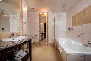 a bathroom with a tub and a sink at Hotel Prezydent Krynica Zdrój in Krynica Zdrój