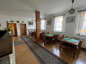 un comedor con mesas, sillas y ventanas en Pension zur Bergbahn, en Lichtenhain