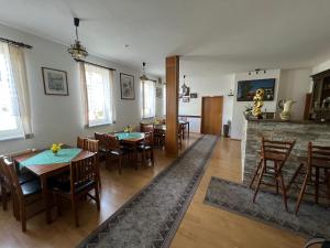 a dining room with tables and chairs and a fireplace at Pension zur Bergbahn in Lichtenhain