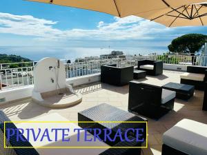 patio terrazzato con tavoli, sedie e ombrellone di Casa Manì ad Anacapri