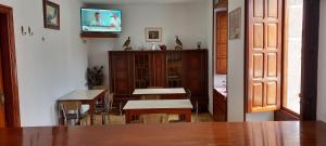 een eetkamer met een tafel en stoelen en een tv bij Pensión Baires in O Coto
