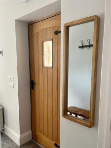 a wooden door with a mirror in a room at Fern Cottage in Lynton