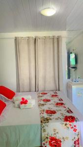 Un dormitorio con una cama con flores rojas. en Flat Visual do Porto, en Fernando de Noronha