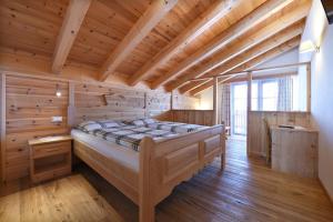 a bedroom with a large bed in a room with wooden ceilings at Agriturismo Soleseid in San Vigilio Di Marebbe