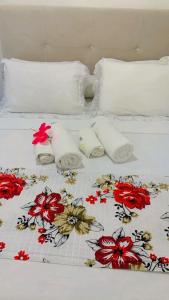 a bed with two towels and flowers on it at Flat Visual do Porto in Fernando de Noronha