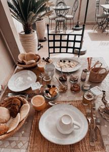 une table avec des assiettes et des bols de nourriture dans l'établissement Riad Louhou, à Marrakech