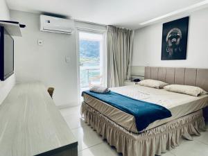 a bedroom with a large bed and a window at Ibiza Barra Hotel in Rio de Janeiro