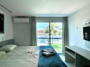 ein Schlafzimmer mit einem Bett und einem großen Fenster in der Unterkunft Ibiza Barra Hotel in Rio de Janeiro