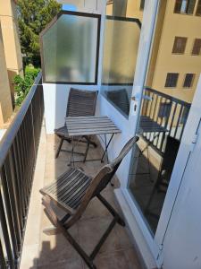 una sedia e 2 sedie sul balcone di SEVEN Hostal a Cala Millor