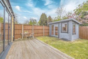 a small shed on a deck next to a fence at Central Windsor, 5 mins to Legoland, Driveway in Windsor