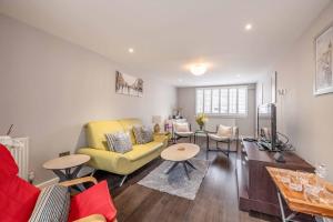 a living room with a yellow couch and a table at Central Windsor, 5 mins to Legoland, Driveway in Windsor