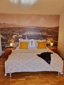 una camera da letto con un grande letto bianco con cuscini gialli di Holiday house Marea with jacuzzi a Crikvenica Altre 52 foto