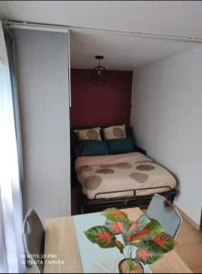 - une petite chambre avec un lit et une table dans l'établissement Appartement charmant et calme en bord de Loire., à Nantes