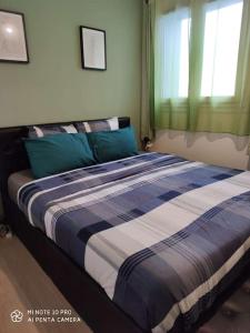- une chambre dotée d'un grand lit avec des draps bleus et blancs dans l'établissement Appartement charmant et calme en bord de Loire., à Nantes